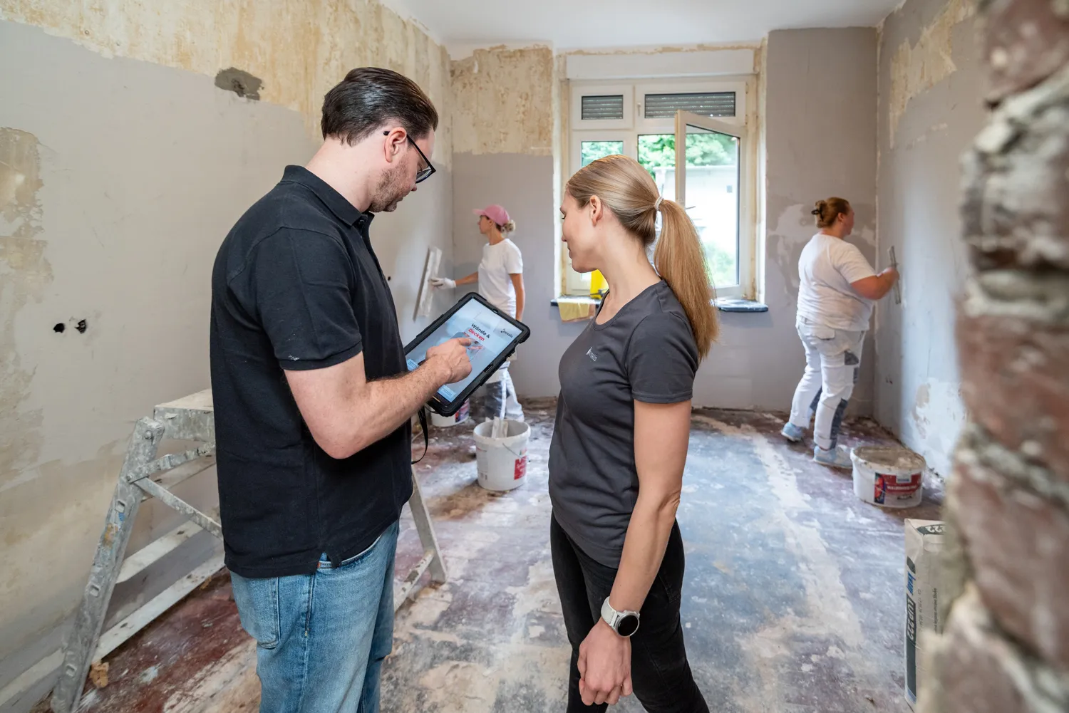 neurealis Bauleitungs-Team bespricht den Sanierungsplan am Tablet